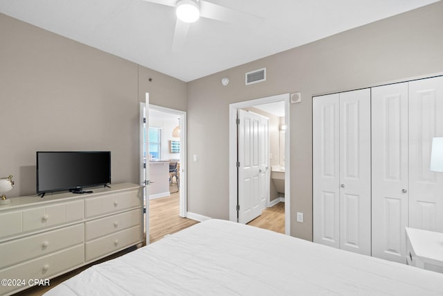 bedroom with connected bathroom, light hardwood / wood-style floors, ceiling fan, and a closet