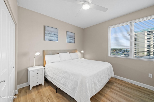 bedroom with ceiling fan, light hardwood / wood-style flooring, and a closet