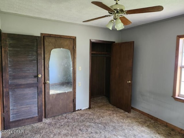 unfurnished bedroom featuring a closet, a textured ceiling, ceiling fan, ornamental molding, and light colored carpet