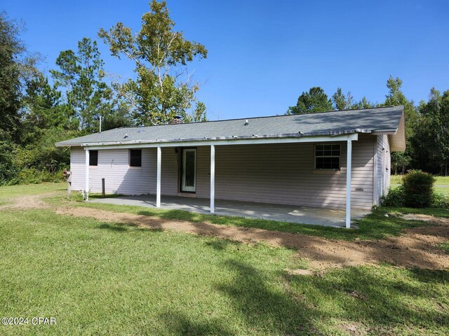 rear view of house with a yard and a patio area