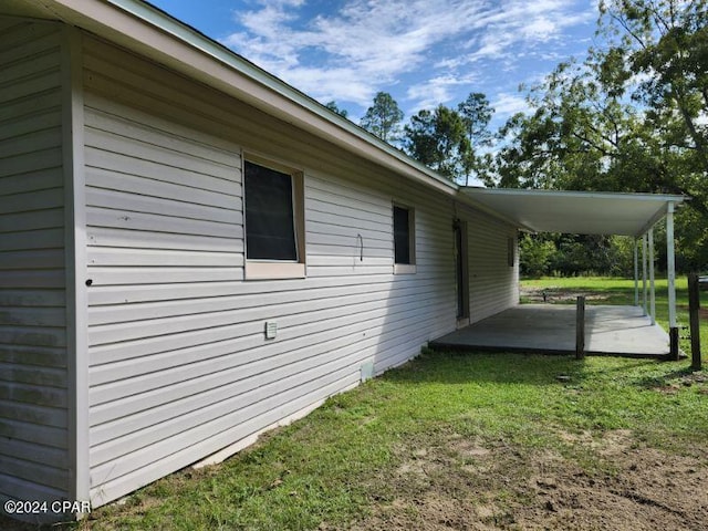 view of property exterior featuring a lawn and a patio area