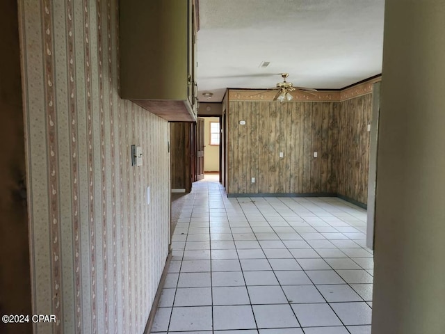 spare room with wooden walls, ceiling fan, and light tile patterned floors