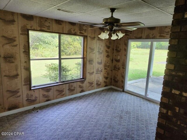 unfurnished room with carpet floors, a paneled ceiling, and ceiling fan