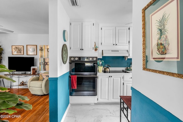 kitchen with double oven, white cabinetry, and custom exhaust hood