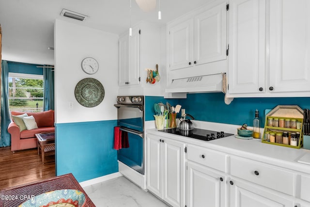 kitchen with white cabinetry, black electric stovetop, double oven, and custom exhaust hood