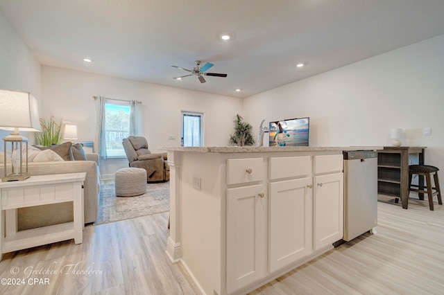 kitchen featuring a kitchen island, ceiling fan, light hardwood / wood-style flooring, and white cabinets