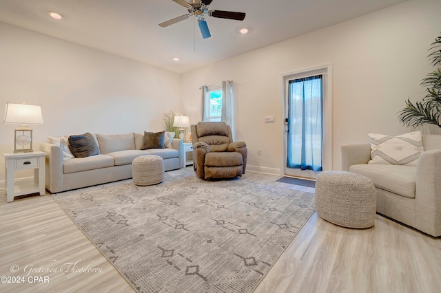 living room featuring light hardwood / wood-style floors and ceiling fan