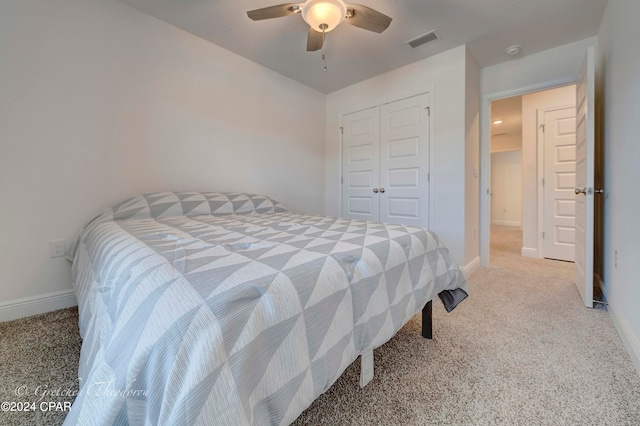 bedroom with ceiling fan, a closet, and light carpet