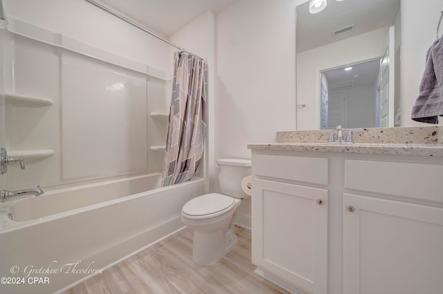 full bathroom with shower / bath combo, hardwood / wood-style floors, vanity, and toilet