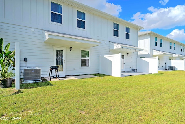 back of property with cooling unit, a lawn, and a patio