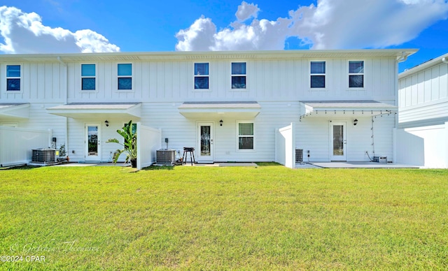 rear view of house featuring a patio, cooling unit, and a yard