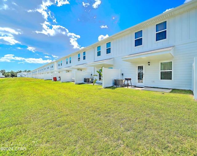 back of house featuring a patio, central AC unit, and a yard