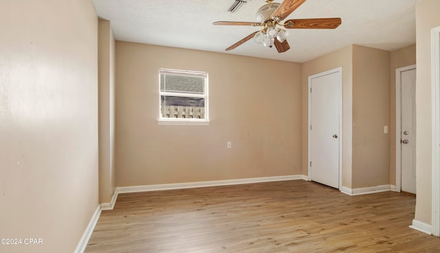 unfurnished room with a textured ceiling, light hardwood / wood-style floors, and ceiling fan