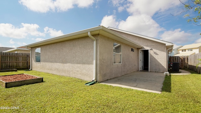 rear view of property with a patio, a lawn, and central air condition unit