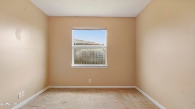 carpeted empty room featuring a textured ceiling