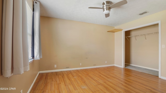 unfurnished bedroom featuring ceiling fan, light hardwood / wood-style flooring, and a closet