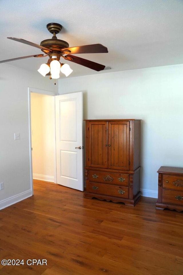 unfurnished bedroom with ceiling fan and dark hardwood / wood-style flooring