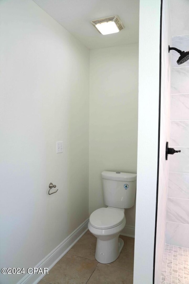 bathroom featuring tile patterned floors, toilet, and tiled shower