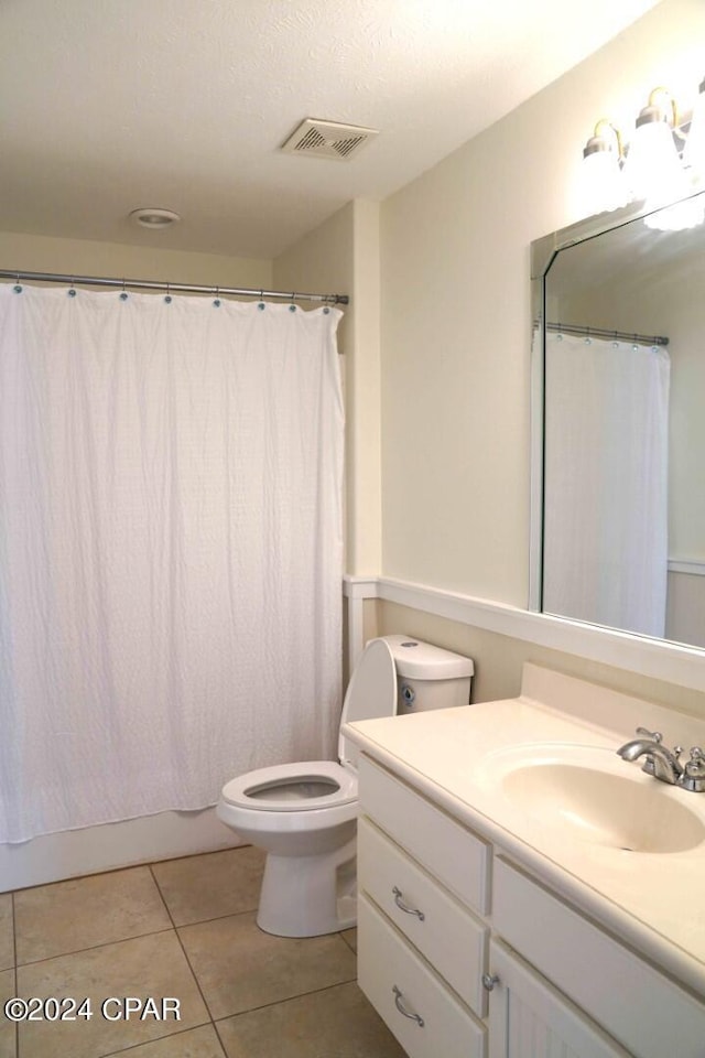 full bathroom with vanity, shower / bath combo, tile patterned floors, and toilet