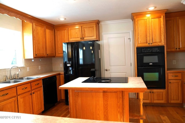 kitchen featuring sink, dark hardwood / wood-style flooring, a kitchen island, decorative backsplash, and black appliances