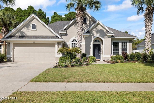 view of front of property with a garage and a front lawn