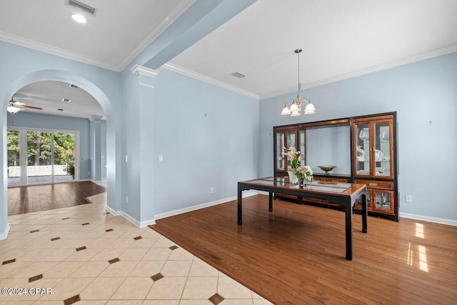 interior space with ornate columns, ceiling fan with notable chandelier, light hardwood / wood-style flooring, and ornamental molding