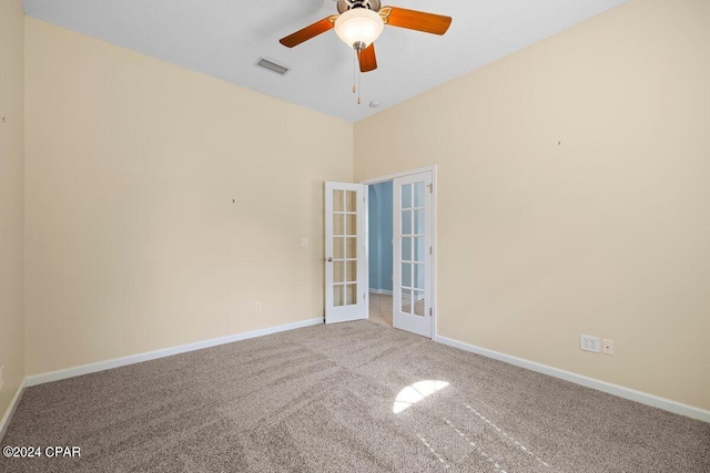 carpeted spare room featuring ceiling fan and french doors