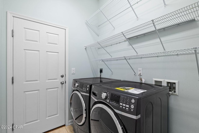 laundry room featuring washer and clothes dryer and light tile patterned floors