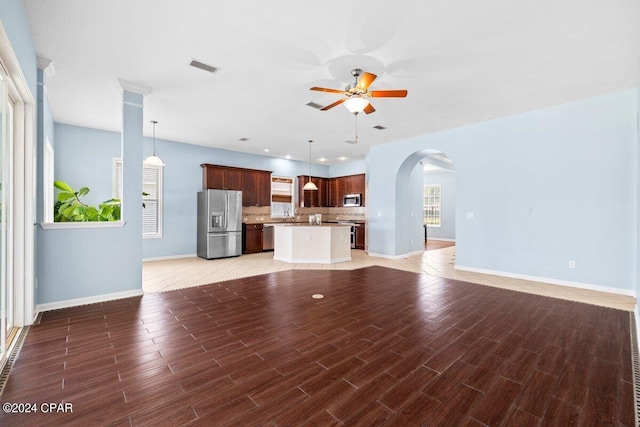 unfurnished living room with ceiling fan and dark hardwood / wood-style floors