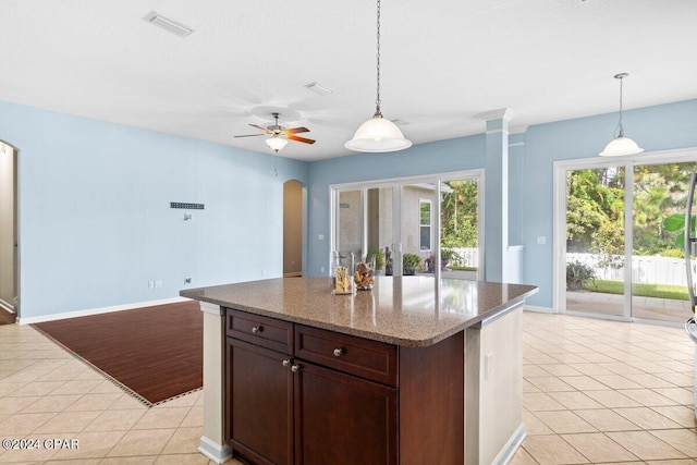 kitchen with light stone countertops, light tile patterned floors, ceiling fan, and pendant lighting