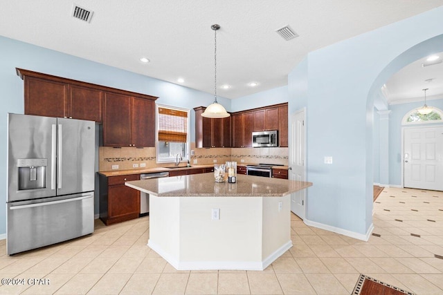 kitchen featuring a center island, appliances with stainless steel finishes, hanging light fixtures, and sink