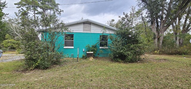 view of side of home with central air condition unit and a lawn