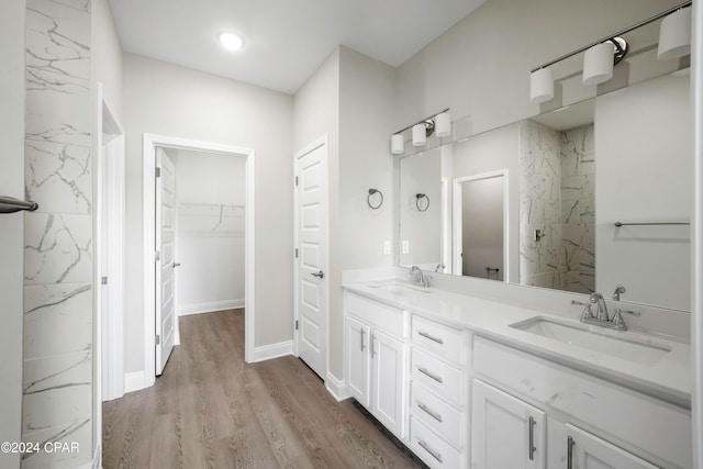 bathroom with a shower, hardwood / wood-style floors, and vanity