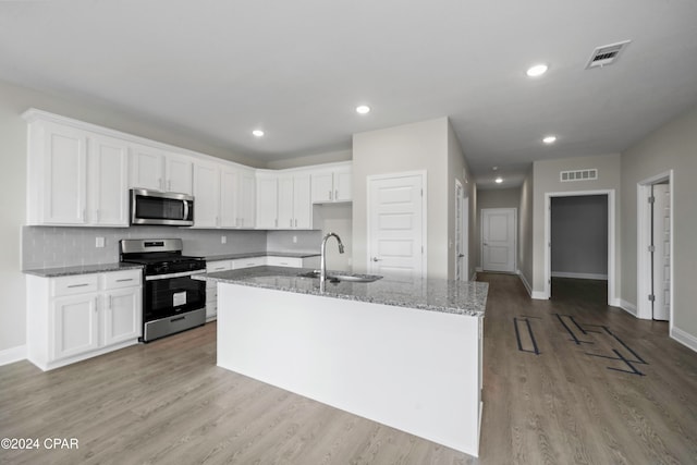 kitchen featuring light stone counters, sink, white cabinets, and appliances with stainless steel finishes