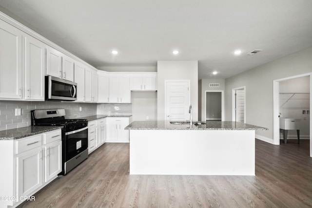 kitchen with a kitchen island with sink, sink, white cabinets, and stainless steel appliances