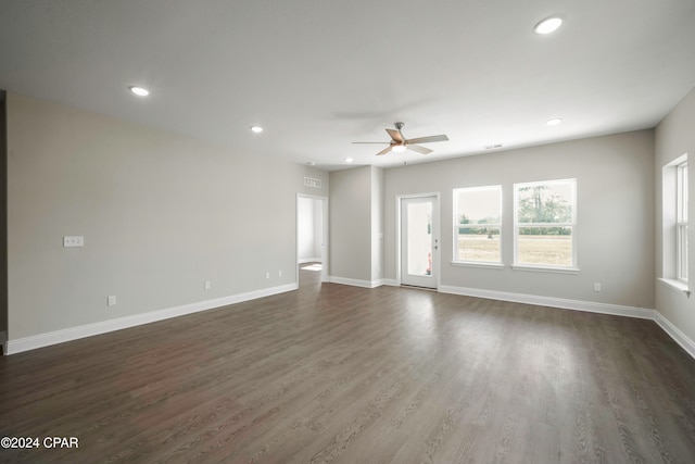 unfurnished living room with ceiling fan and dark wood-type flooring