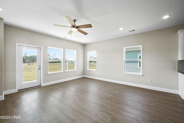 unfurnished room featuring ceiling fan, plenty of natural light, and dark wood-type flooring