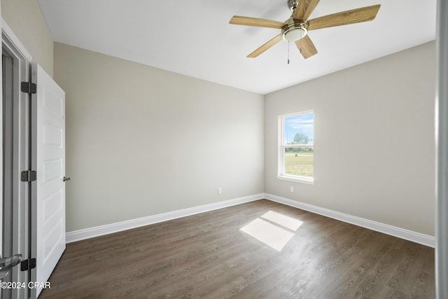 unfurnished room with ceiling fan and dark wood-type flooring