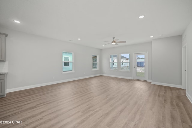 unfurnished living room featuring plenty of natural light, light hardwood / wood-style floors, and ceiling fan