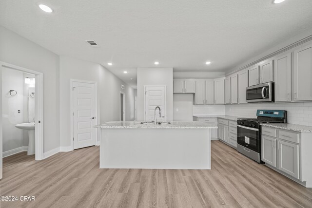 164 Canvas Ln Unit 72, Port St Joe, FL 32456 - kitchen with stainless steel appliances, light wood finished floors, tasteful backsplash, a center island with sink, and recessed lighting