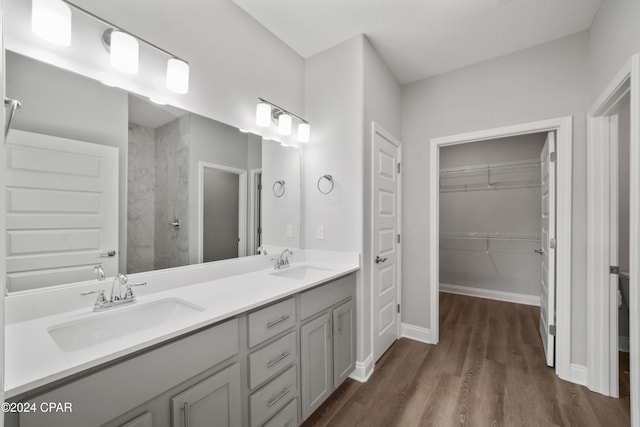 bathroom with hardwood / wood-style floors, vanity, and walk in shower