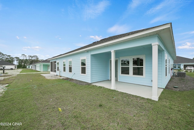 back of property with a lawn and cooling unit