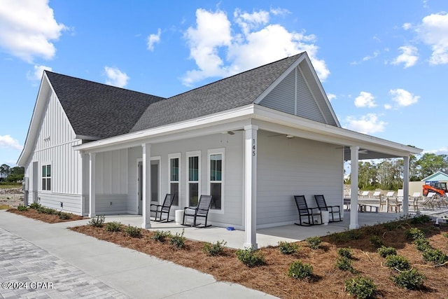 view of side of home featuring covered porch and a patio