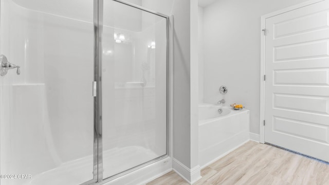 bathroom with plus walk in shower and hardwood / wood-style flooring