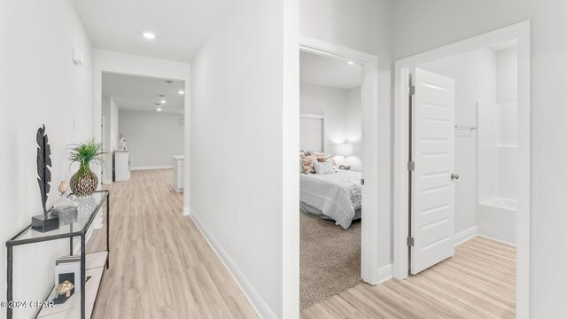 corridor featuring recessed lighting, light wood-style flooring, and baseboards