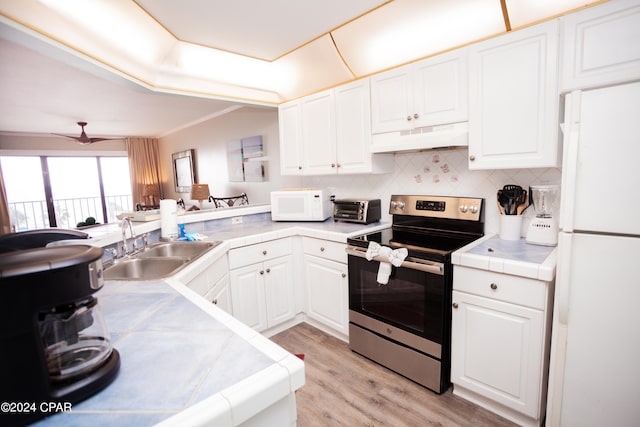 kitchen featuring light hardwood / wood-style floors, white cabinets, white appliances, tile countertops, and sink