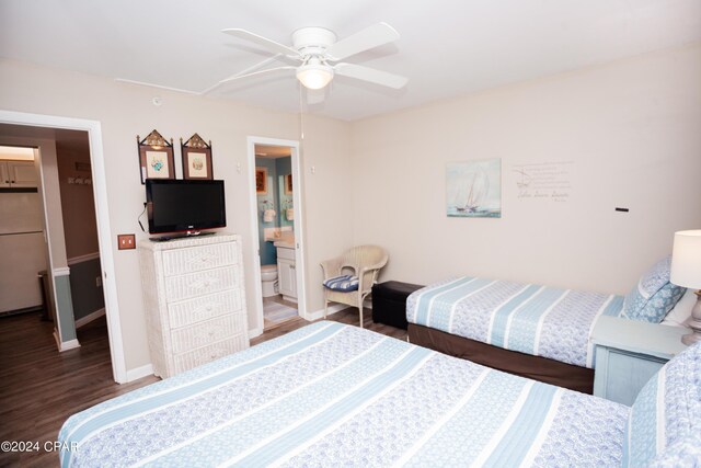 bedroom featuring white refrigerator, dark hardwood / wood-style floors, ceiling fan, and ensuite bathroom