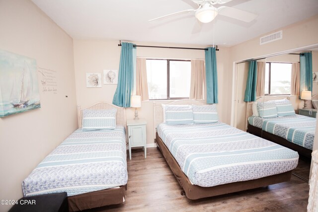 bedroom featuring wood-type flooring, multiple windows, and ceiling fan