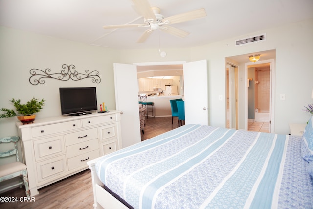 bedroom featuring ceiling fan, light hardwood / wood-style floors, and white fridge