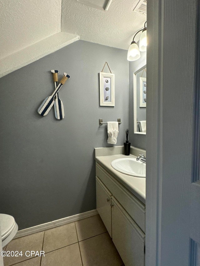 bathroom with tile patterned floors, a textured ceiling, vanity, and toilet